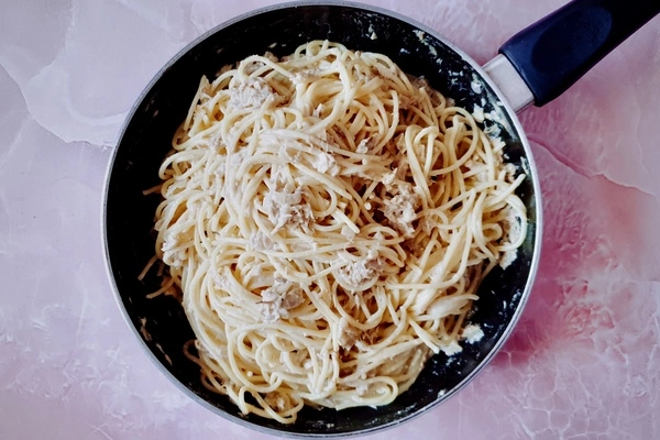 Creamy garlic canned tuna sauce mixed with cooked spaghetti in a skillet