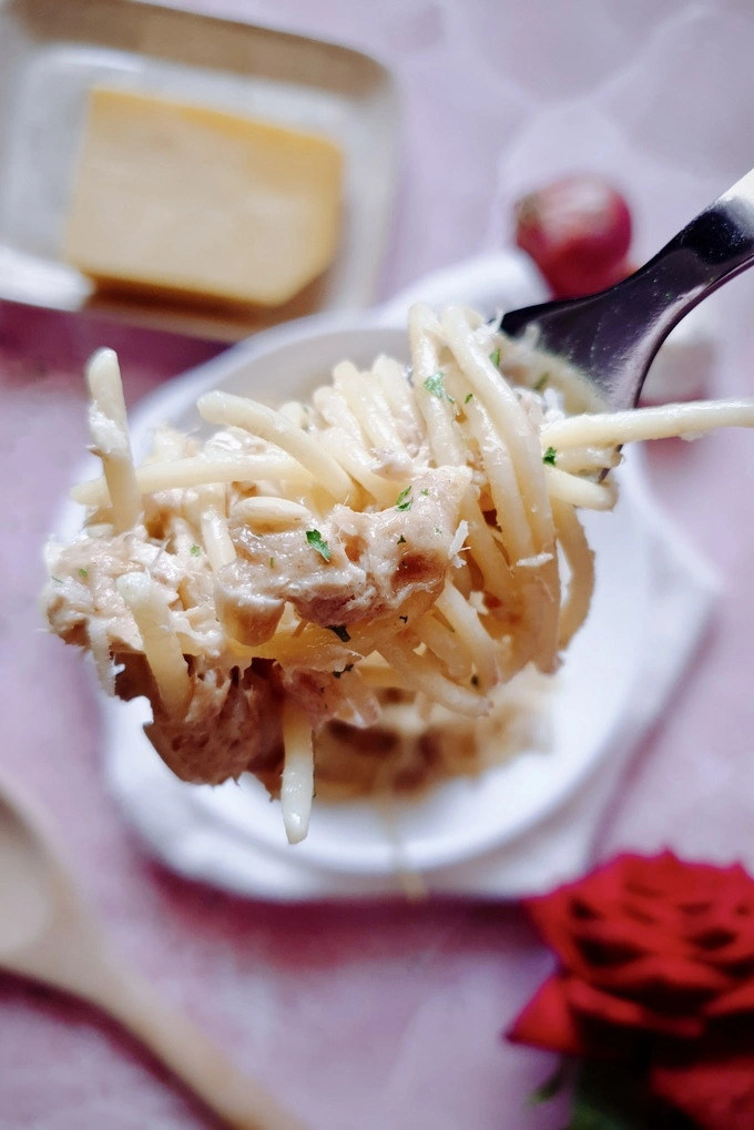 A creamy garlic canned tuna pasta bite on a fork