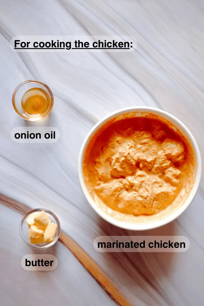 Onion oil, butter cubes and marinated chicken in separate bowls