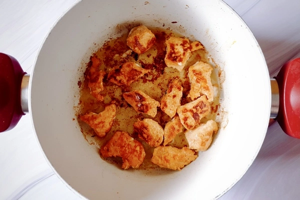 Cooked chicken cubes in a Dutch oven