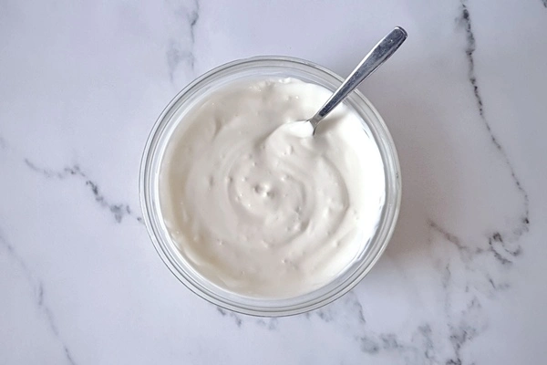 Creamy garlic sauce in a bowl with a spoon