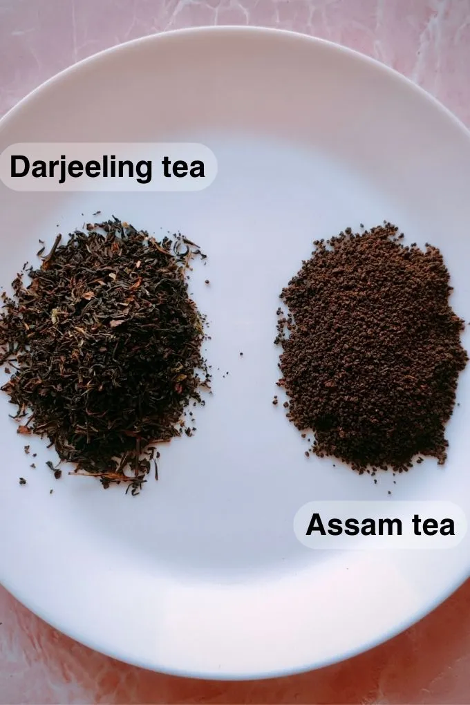 A heap of Darjeeling tea powder next to a heap of Assam tea powder on a white plate