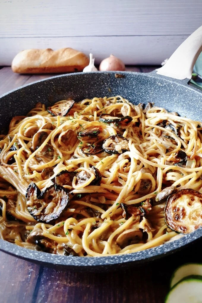 A close up of Best One Pot Zucchini Mushroom Pasta {Creamy Vegan Recipe} in a skillet