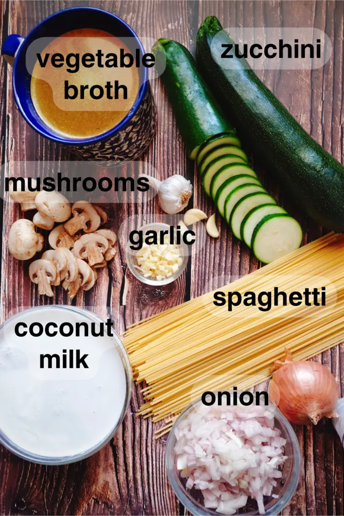 Ingredients to make one pot zucchini mushroom pasta like vegetable broth, zucchini, mushrooms, garlic, coconut milk, spaghetti and onion