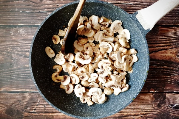 A skillet with sliced mushrooms in it