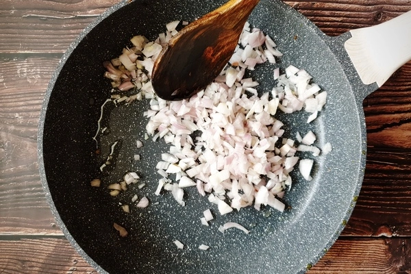 A skillet with a little oil and diced onions in it