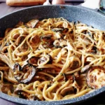 A close up of Best One Pot Zucchini Mushroom Pasta {Creamy Vegan Recipe} in a skillet