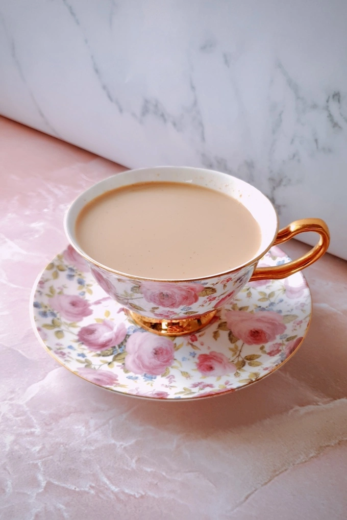 Side view of Homemade Japanese Royal Milk Tea in a fancy teacup over a plate