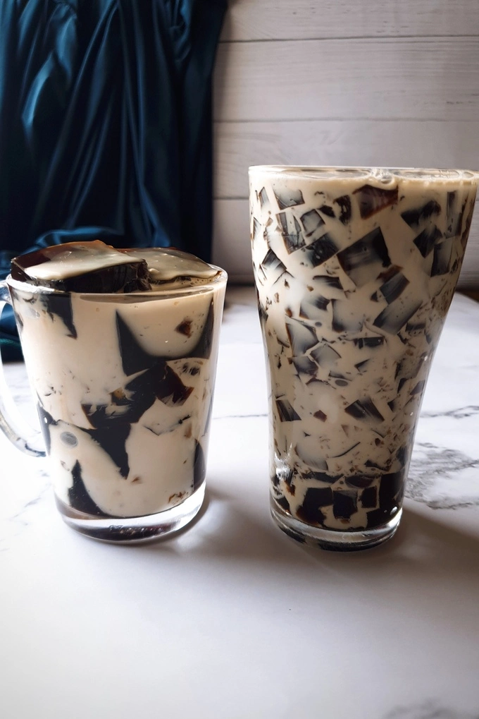 Cubes of Homemade Coffee Jello Recipe with Condensed Milk Cream in a glass mug and a tall glass