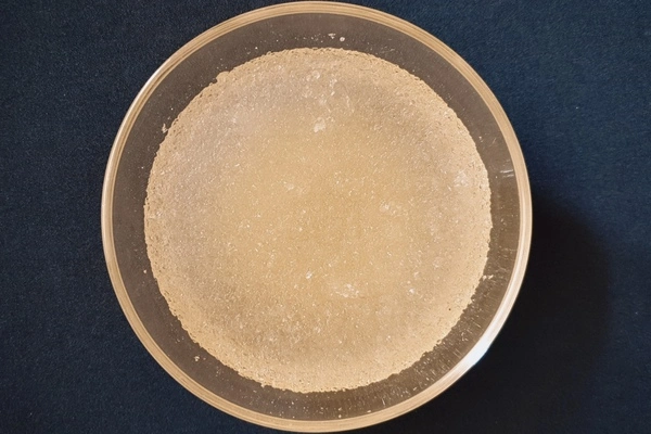 Top view of a glass bowl with water and gelatin powder bloomed in it